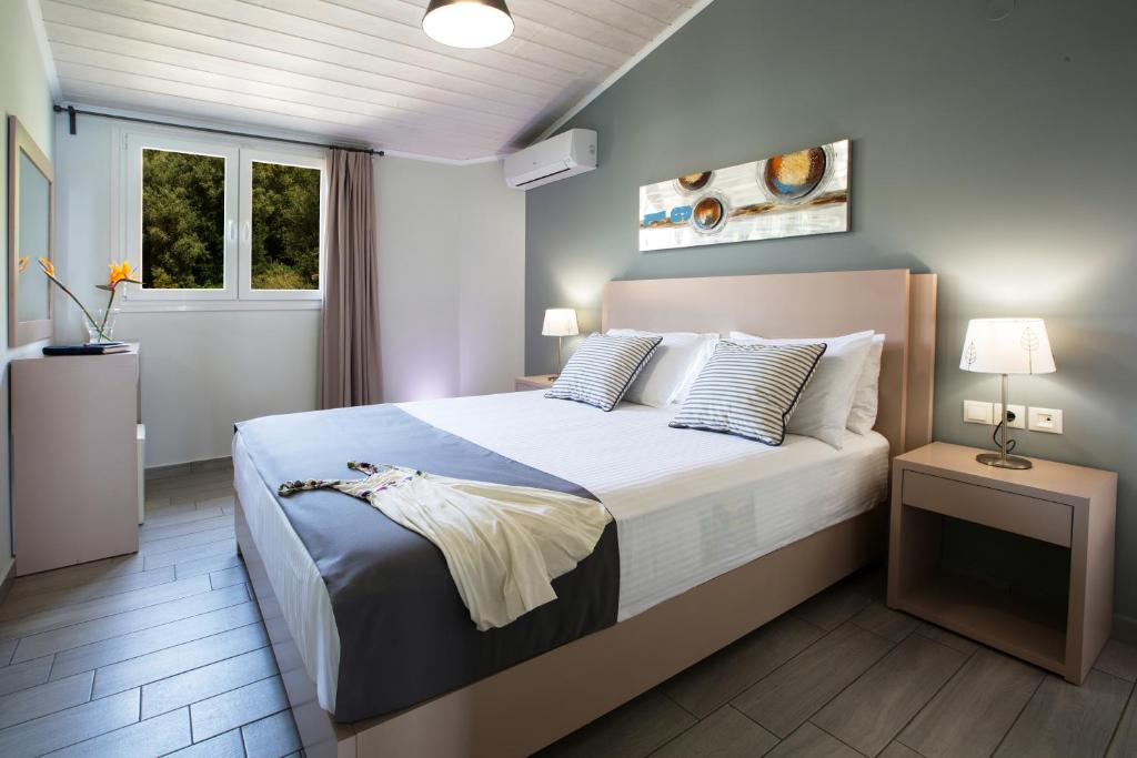 a bedroom with a large bed and a window at Captain Nick Aparthotel in Mikros Gialos