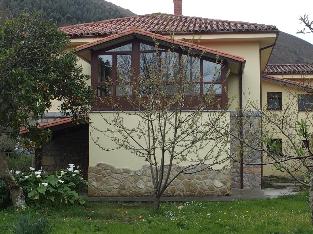 a house with a large window on the side of it at La Nogalera in Nueva de Llanes