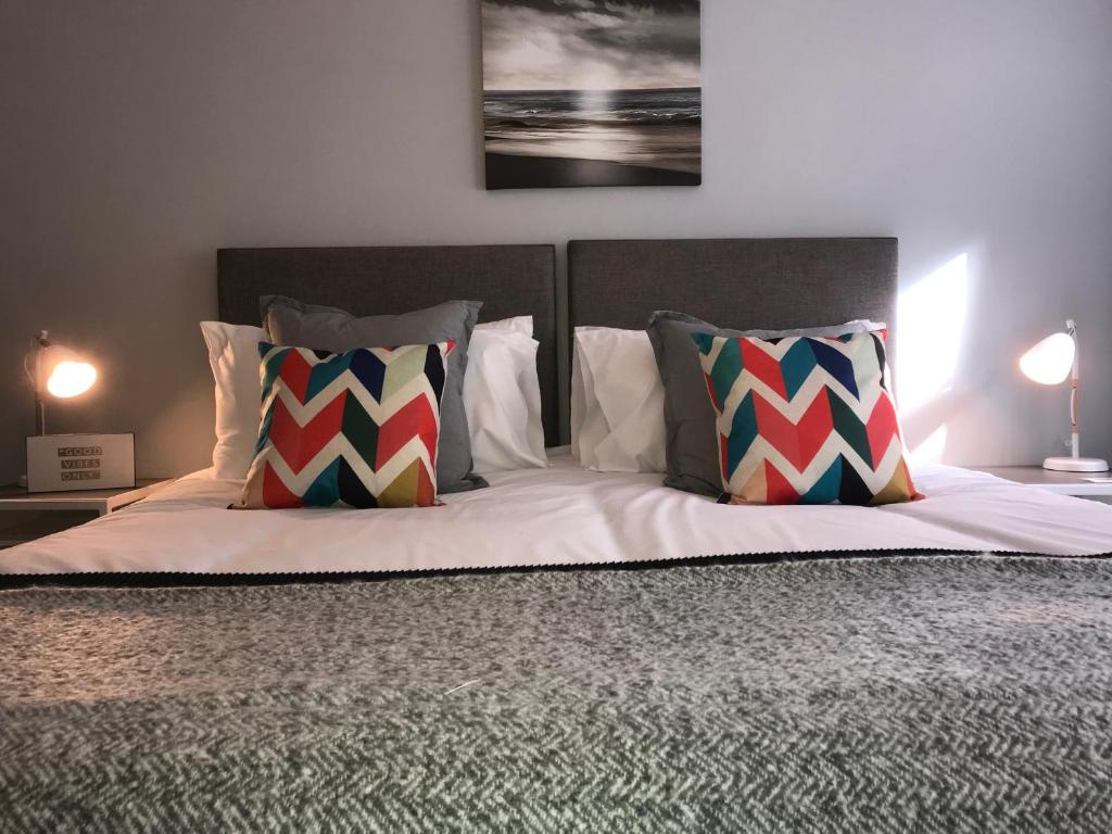 a bedroom with a bed with two pillows on it at The Garden Apartment in Leamington Spa