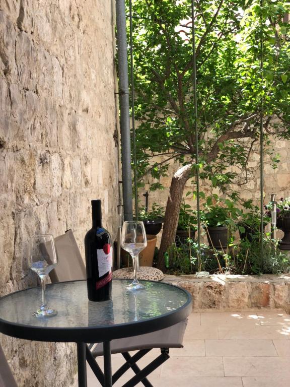 a bottle of wine sitting on a table with two glasses at Elegant Apartment Leila in Dubrovnik