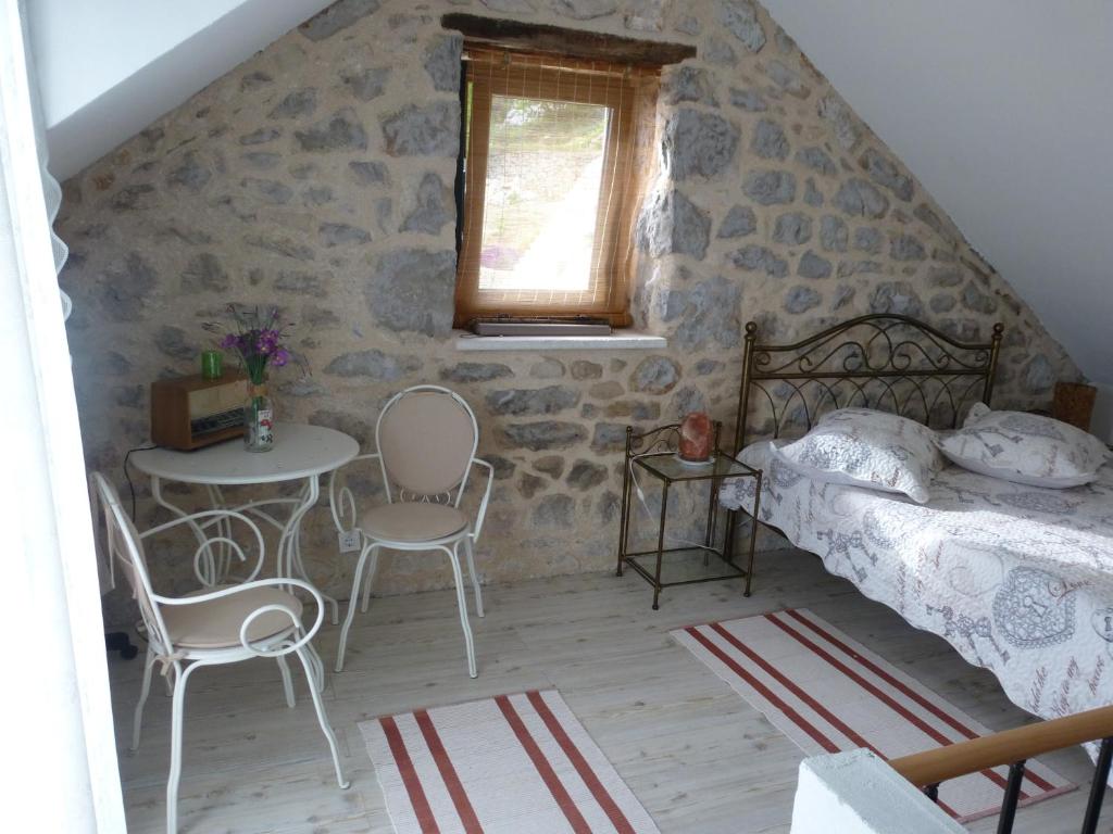 - une chambre avec un lit, une table et des chaises dans l'établissement Kuća za odmor Viola, à Živogošće