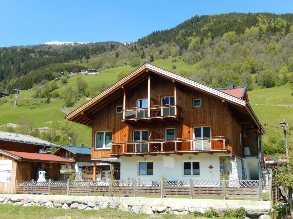 a large wooden house with a balcony at ff Appartements in Bramberg am Wildkogel