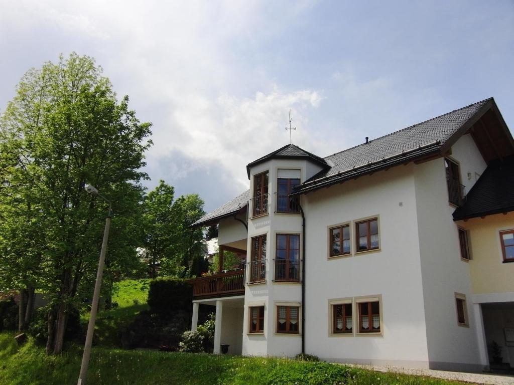 una casa blanca con techo negro en Ferienwohnung Alte Poststraße, en Kurort Oberwiesenthal