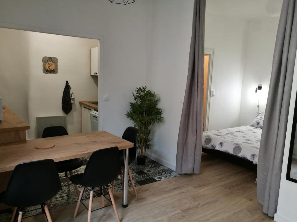 um quarto com uma mesa e cadeiras e uma cama em Appartement les Regrattiers em Poitiers