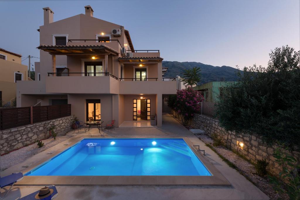 Villa con piscina frente a una casa en The Lake House, en Mouríon