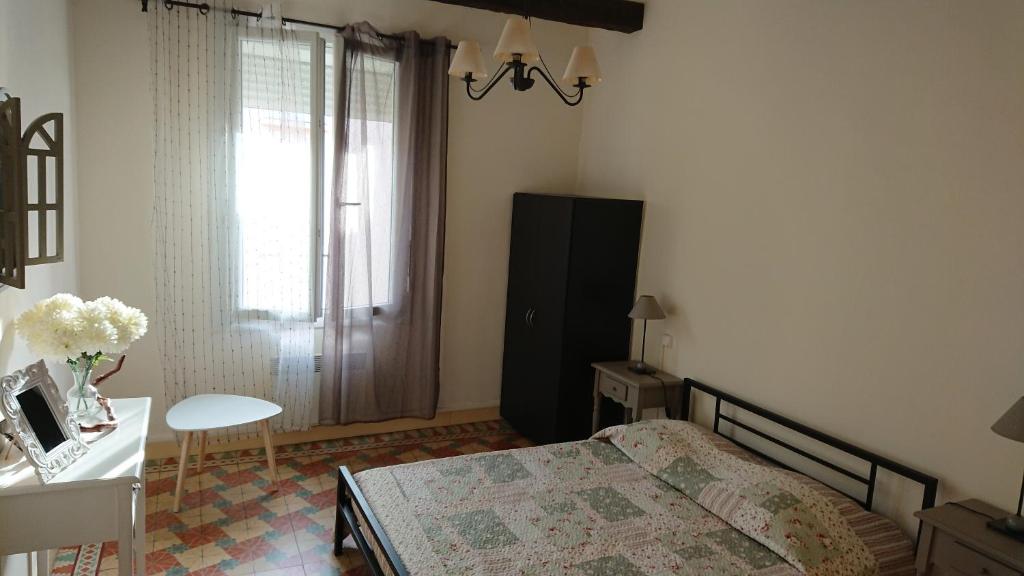 a bedroom with a bed and a desk and a window at Chez'Artistes in Argelès-sur-Mer