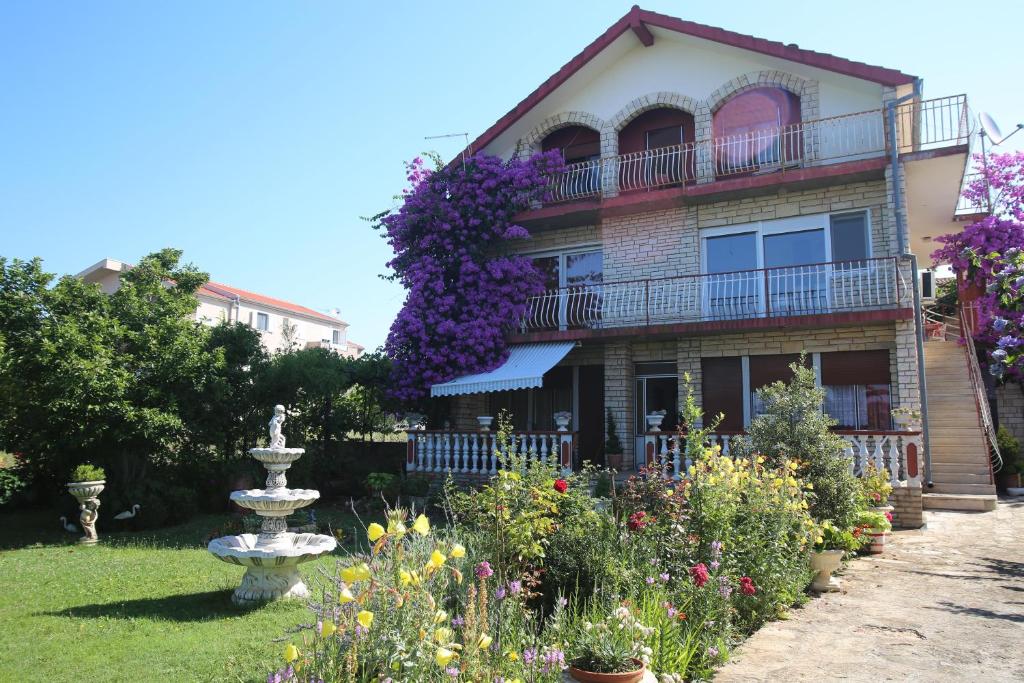 dom z ogrodem kwiatowym przed nim w obiekcie Apartment Michelle w Bibinje