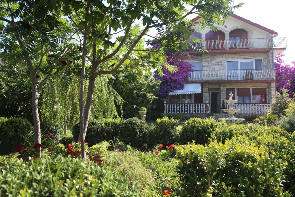 stary dom z ogrodem przed nim w obiekcie Apartment Michelle w Bibinje
