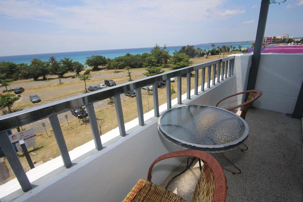 a balcony with a table and chairs and the ocean at Kenting Waterfront Hotel in Kenting