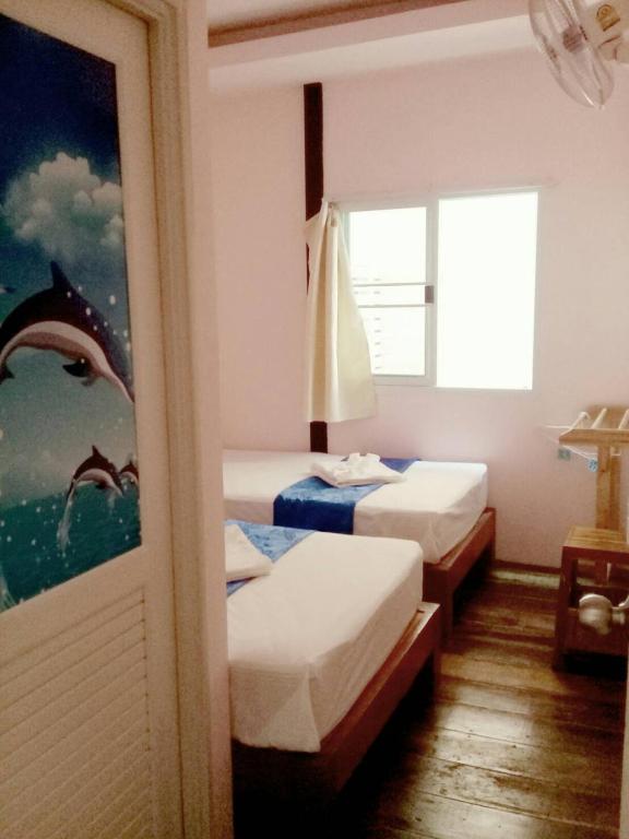 a room with two beds and a window at Sangchan hostel in Ko Lipe