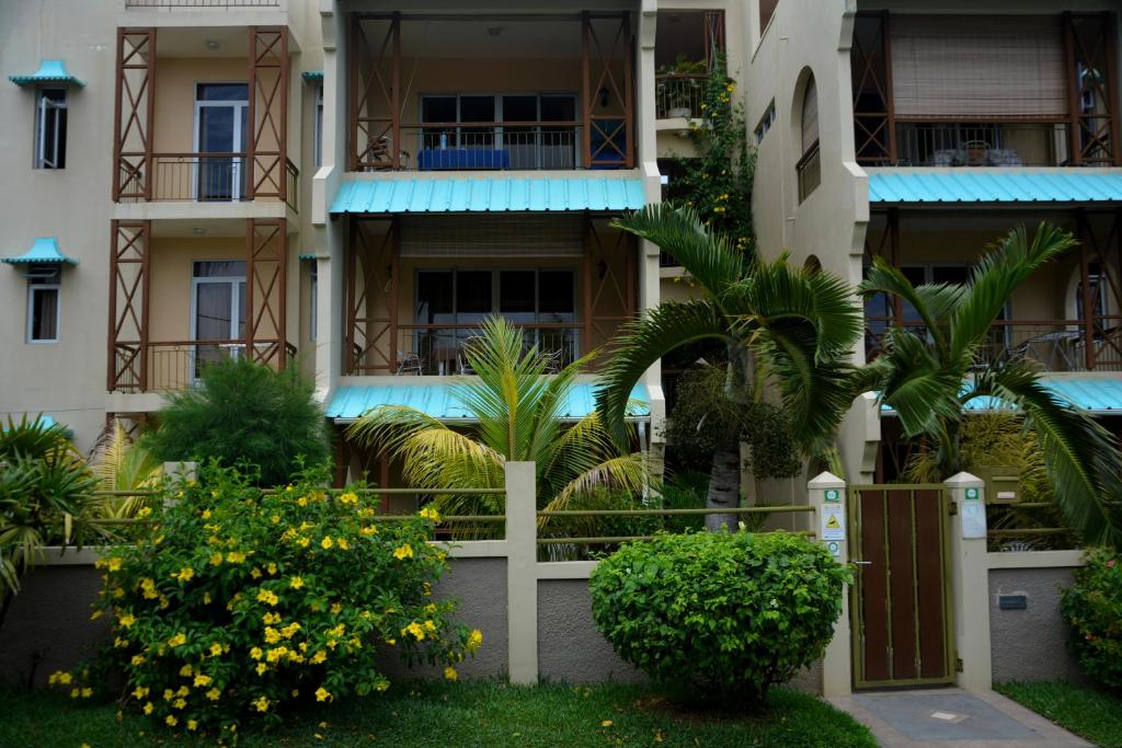 a building with trees and plants in front of it at Villas Pingouin in Blue Bay
