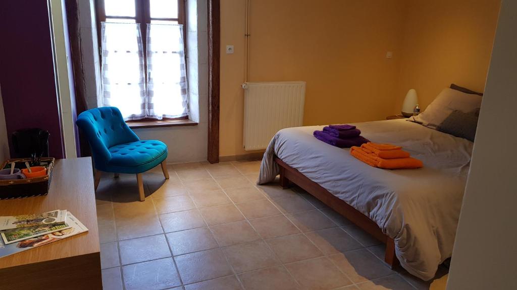 a bedroom with a bed and a blue chair at Des Km à La Ronde in La Ronde