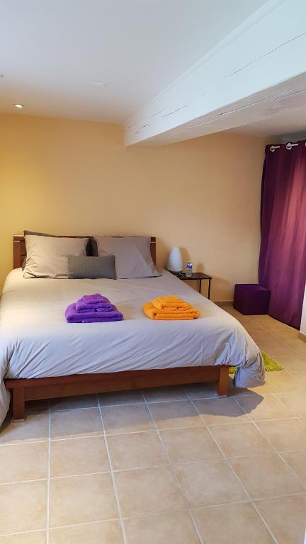 a bedroom with a large bed with purple sheets at Des Km à La Ronde in La Ronde