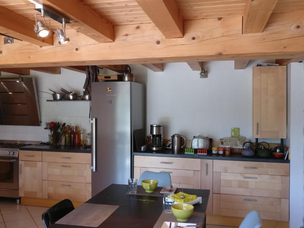 a kitchen with a table and a refrigerator at Des Km à La Ronde in La Ronde