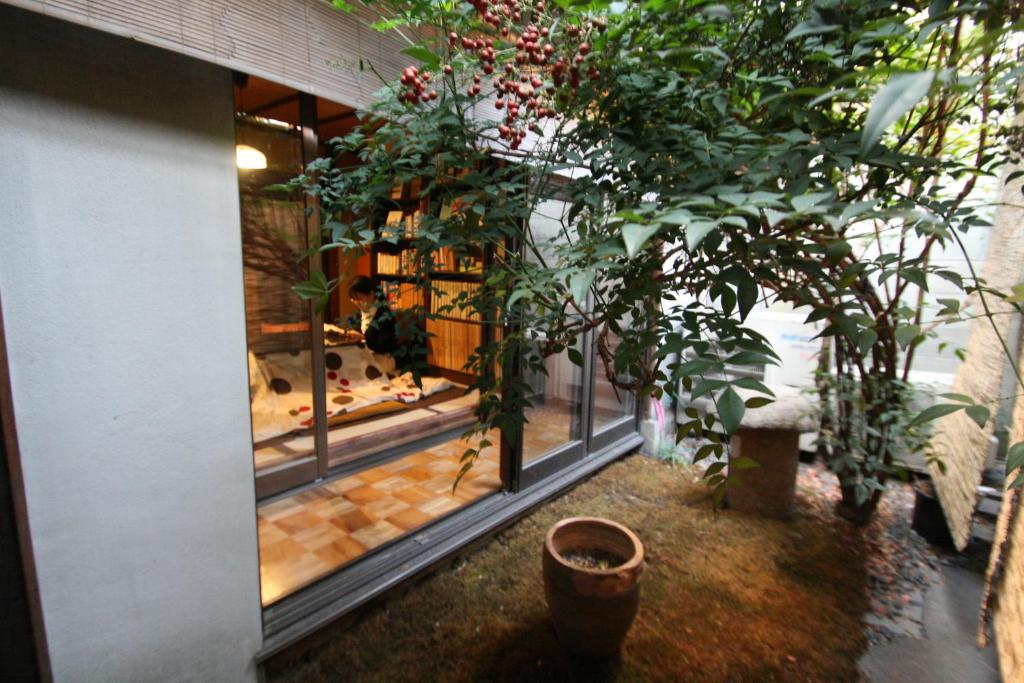 Habitación con una gran ventana con plantas. en HARUYA Higashiyama, en Kioto
