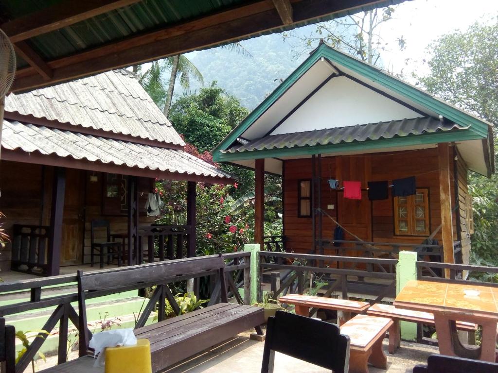 a small building with a table and benches on a deck at SuanPhao Guesthouse in Muang Ngoy