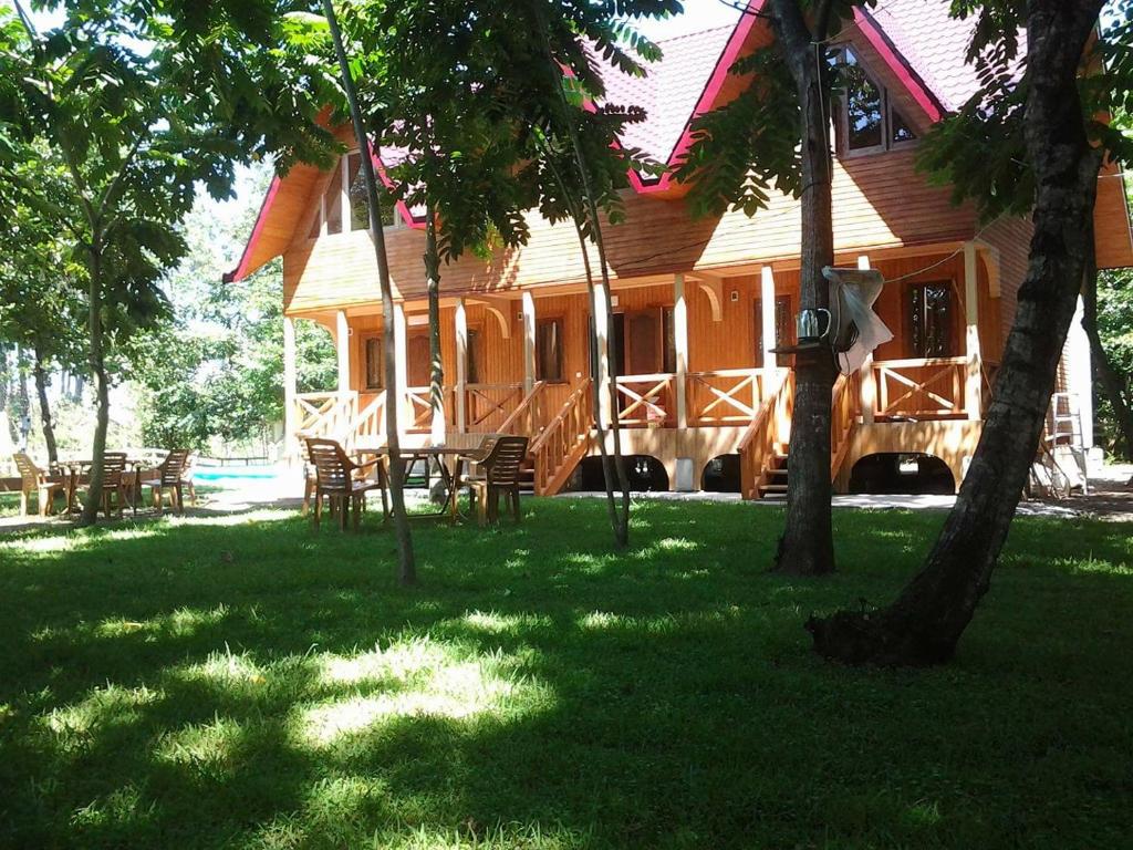 a wooden house with tables and chairs in the grass at Shekhvetili Cottages 2N in Shekvetili