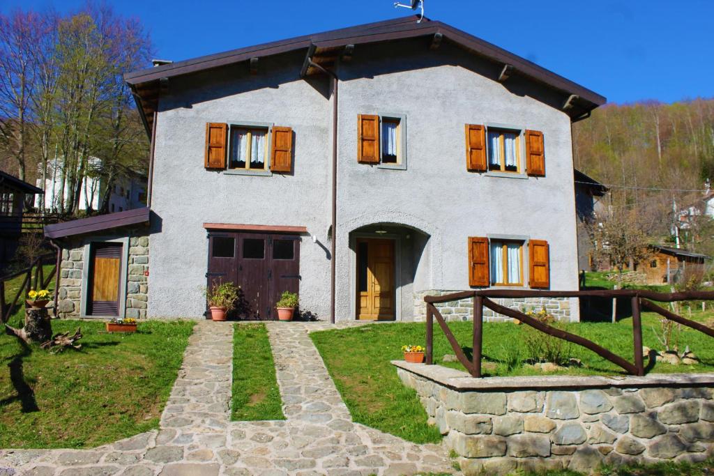 una casa con una pasarela de piedra delante de ella en Cottage Abetone La Capanna in Tuscany, en Abetone