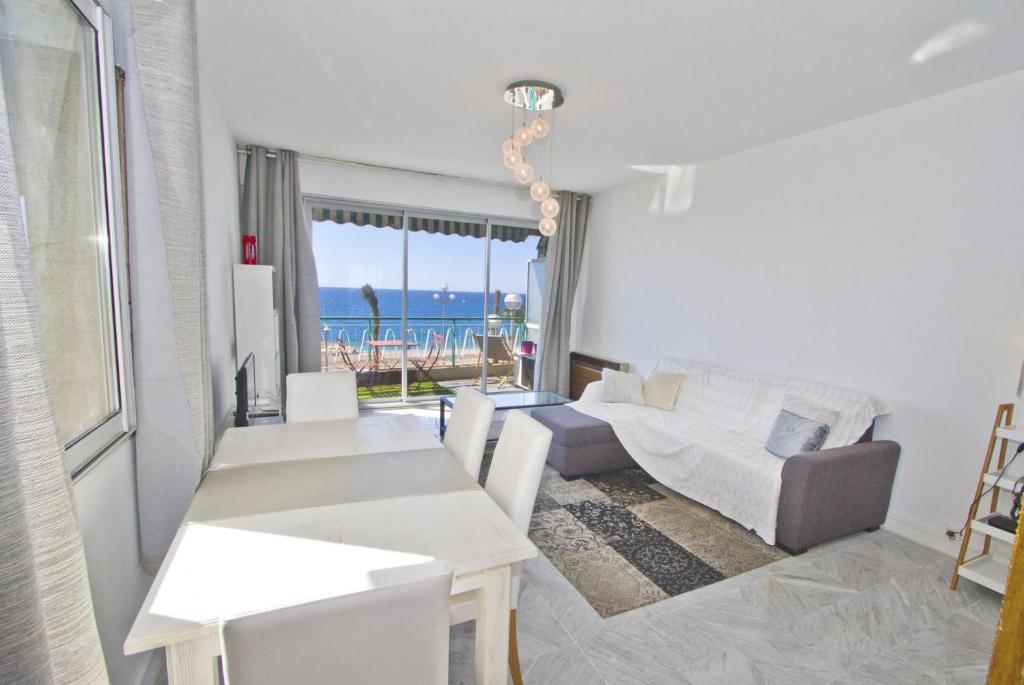 d'un salon avec un mobilier blanc et une vue sur l'océan. dans l'établissement MILORD PROMENADE 2 - PROMENADE HOLIDAY, à Nice