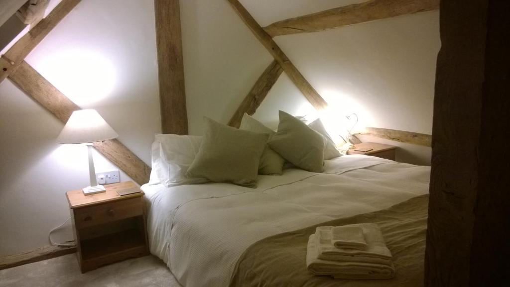 a bedroom with a large white bed with two lamps at The Apple Loft in Ludlow