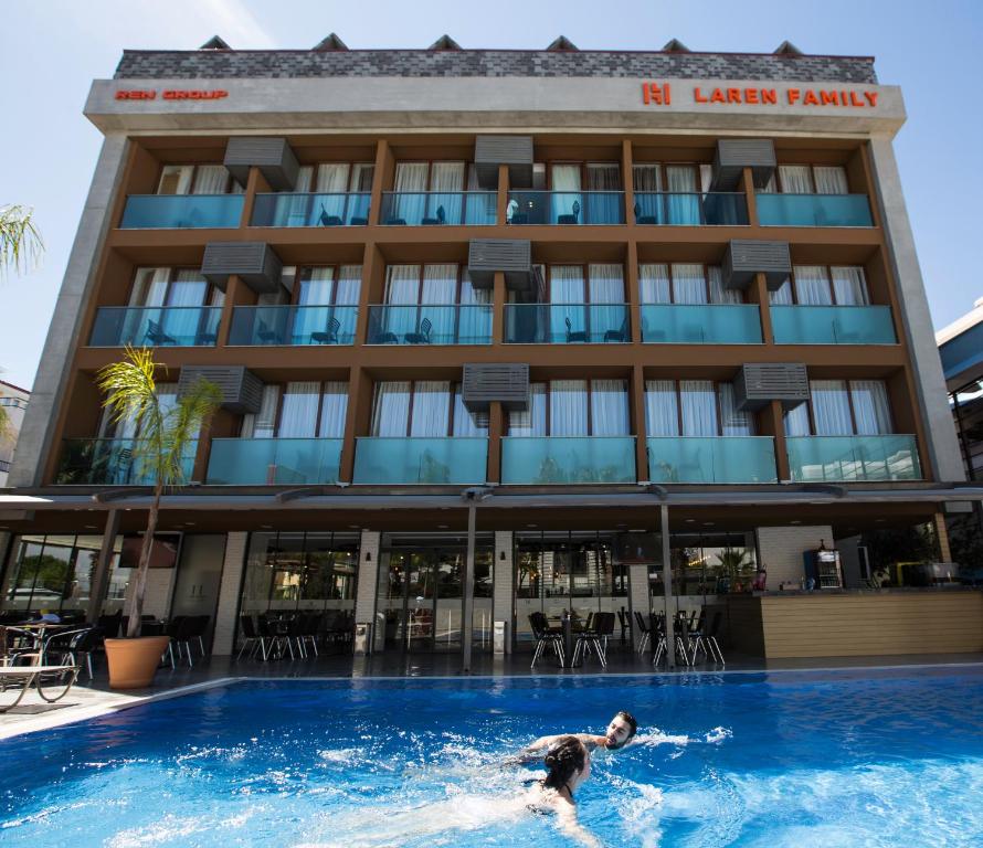 a man swimming in the pool in front of a hotel at Laren Family Hotel & Spa - Boutique Class in Antalya