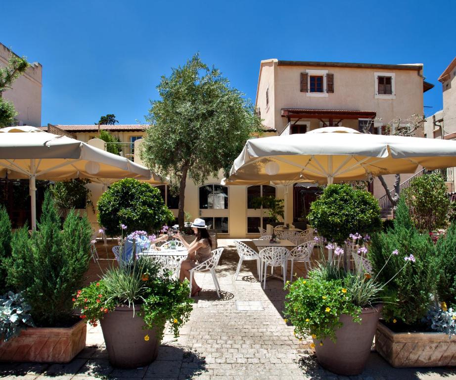 a person sitting at a table under umbrellas at Templers House Boutique hotel in Haifa