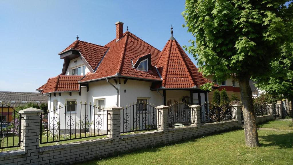 une maison avec une clôture devant elle dans l'établissement Balaton White House, à Vonyarcvashegy