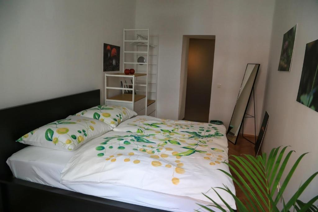 グラーツにあるlovely apartment in the heart of Grazのベッドルーム1室(花が咲く白いベッド1台付)