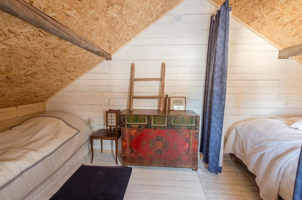 um quarto com uma cama, uma cadeira e uma mesa em Stuga Petruslogen em Malung