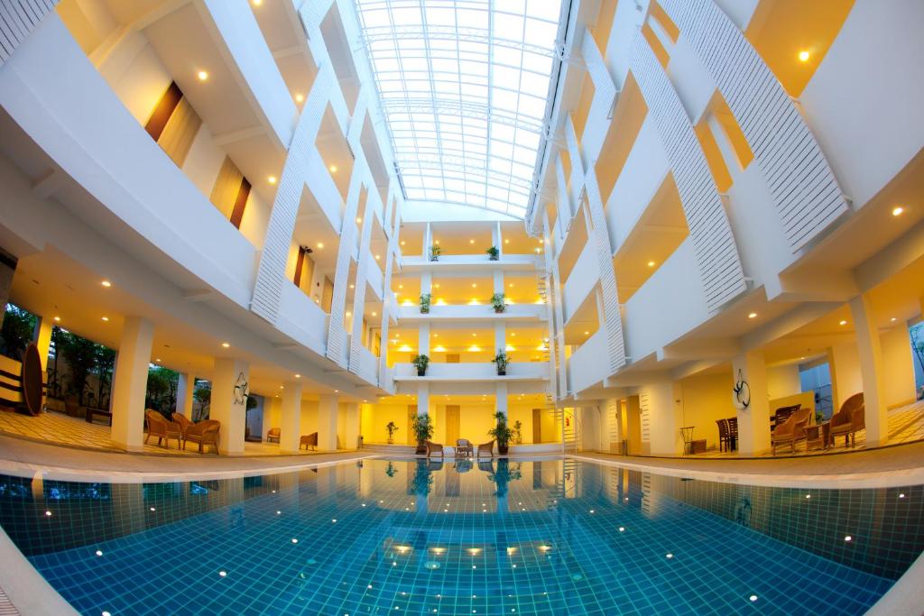una piscina en un edificio con techo en Trang Hotel Bangkok - SHA Plus, en Bangkok