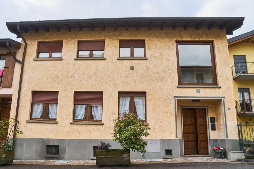 uma casa de tijolos com janelas e uma porta em Appartamento Clivo em Solto Collina