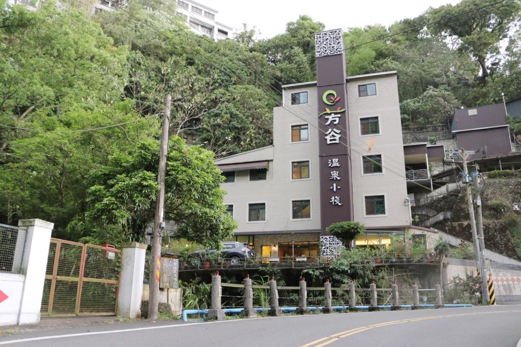 um edifício com uma placa na berma de uma estrada em Fungo Hotel em Baihe