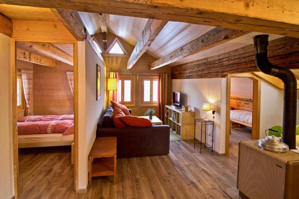 ein Schlafzimmer mit 2 Betten und einem Sofa in einem Zimmer in der Unterkunft Appartement sous les combles - Chalet La Biolle - Vercorin in Vercorin