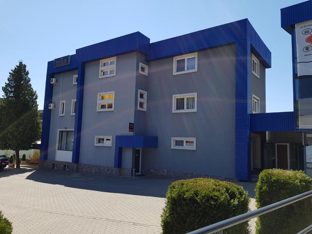 un gran edificio gris con detalles azules en Pension Eurosandoor, en Sovata