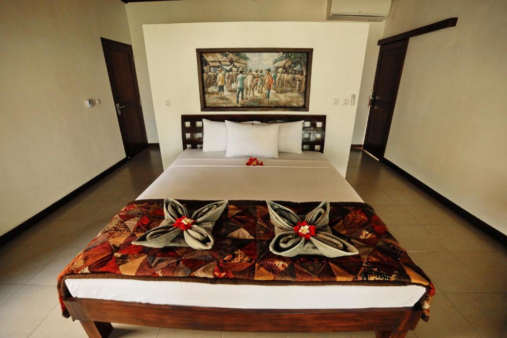 a bedroom with a bed with bows on it at Bali Dream House in Amed