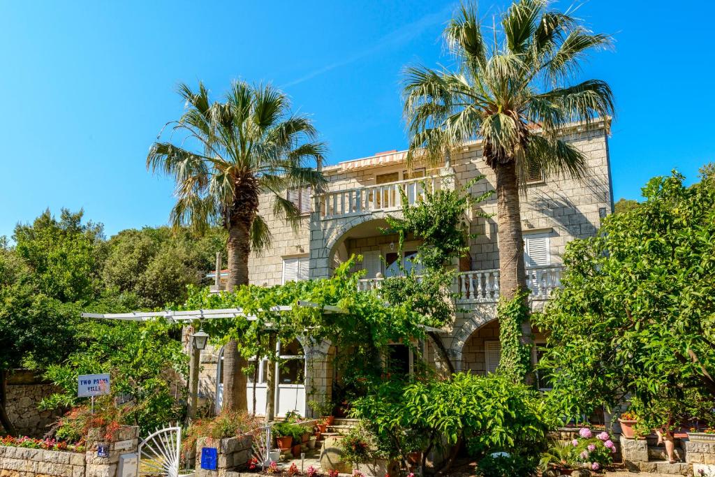 un bâtiment avec des palmiers en face de celui-ci dans l'établissement Two Palms Villa, à Zaton