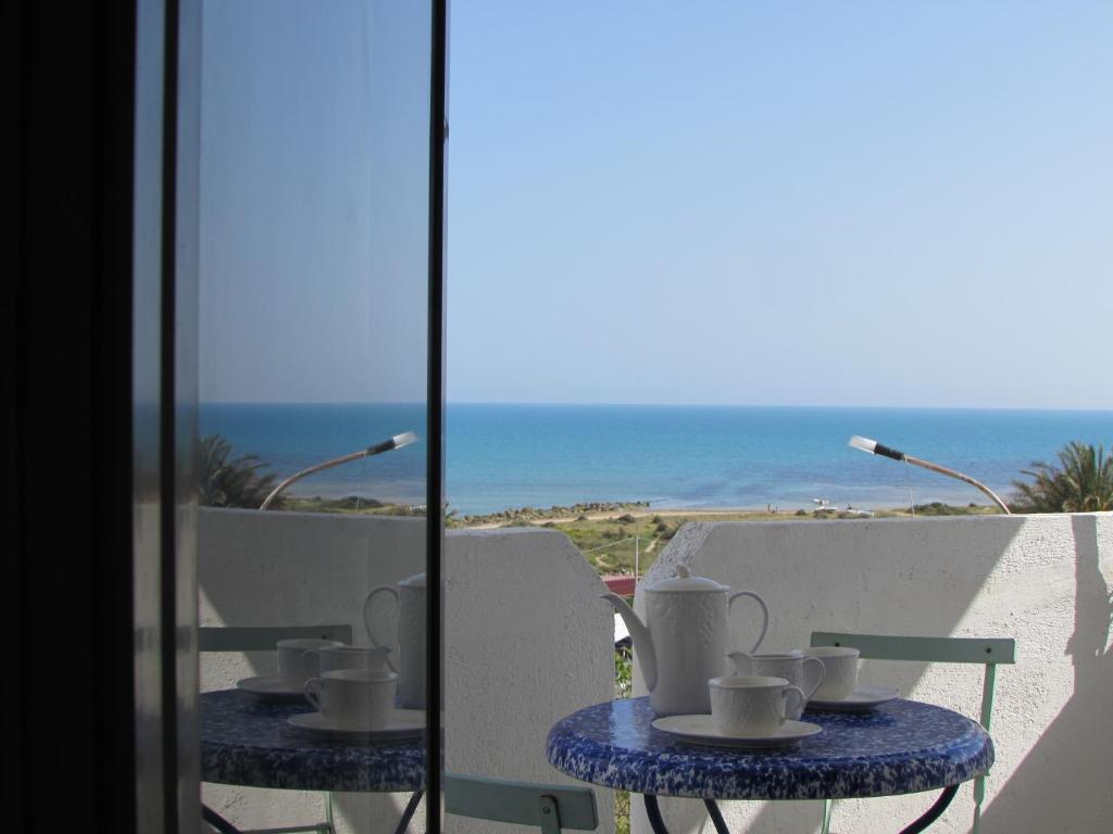 due tavoli con tazze da tè e vista sull'oceano di Villa Majata a Realmonte