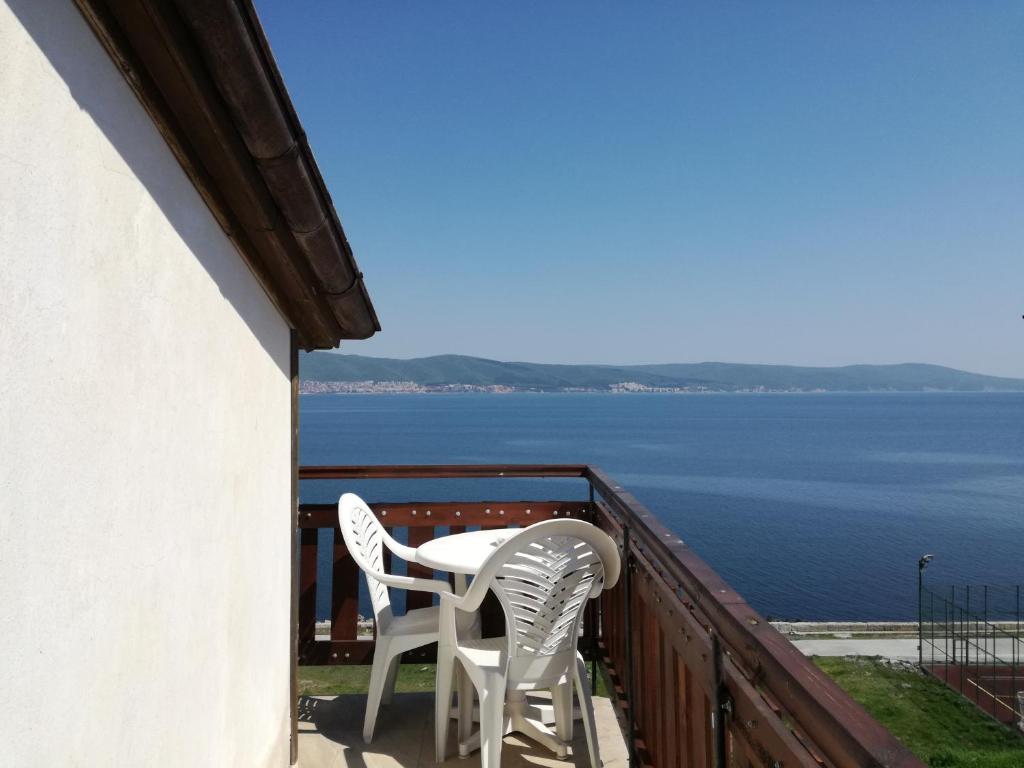 a balcony with two white chairs and a view of the water at Apartment Marchela in Nesebar
