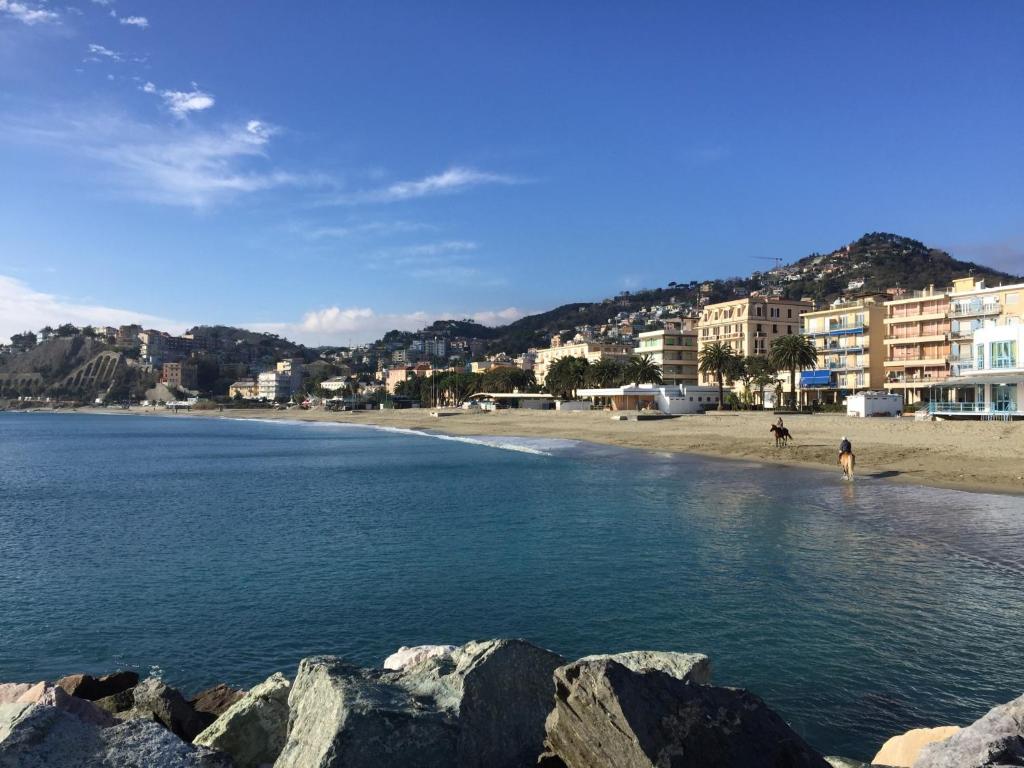 una playa con un grupo de personas en el agua en Appartamenti Mare Azzurro by Holiday World, en Albisola Superiore