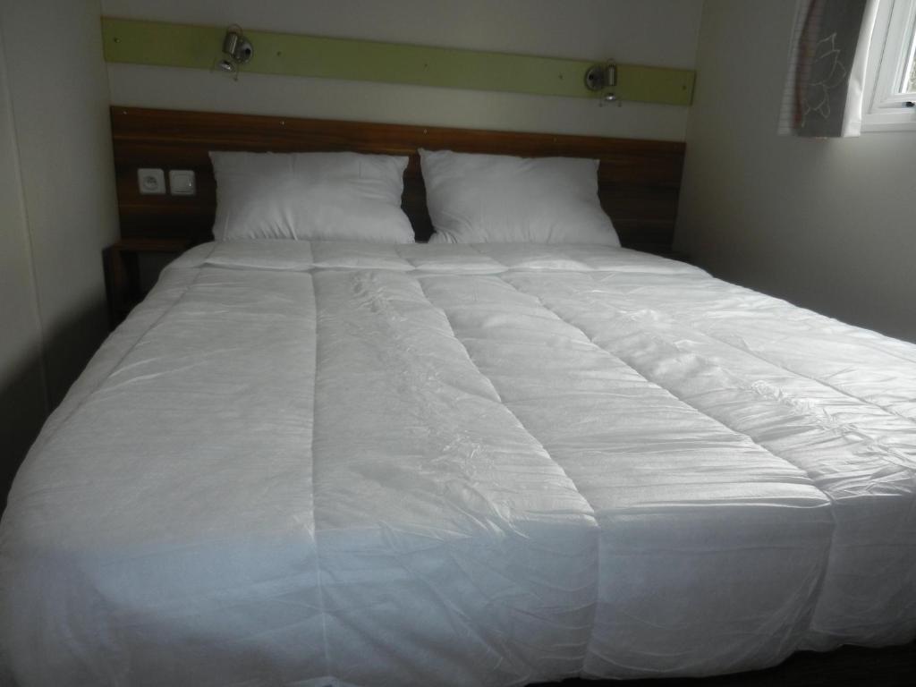 a large white bed with white sheets and pillows at Mareva37 in Trogues