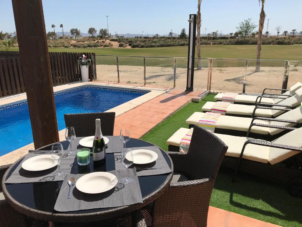 un tavolo e sedie seduti su un patio con piscina di Lucella Apt a Murcia