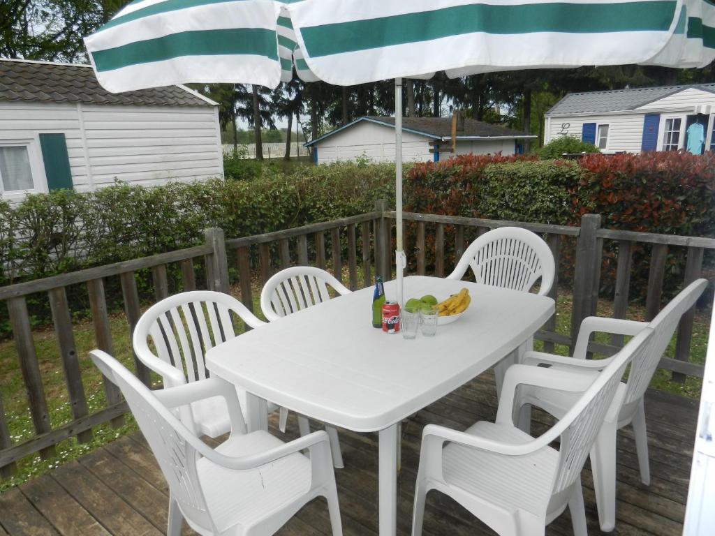 a white table with white chairs and an umbrella at Mareva37 in Trogues