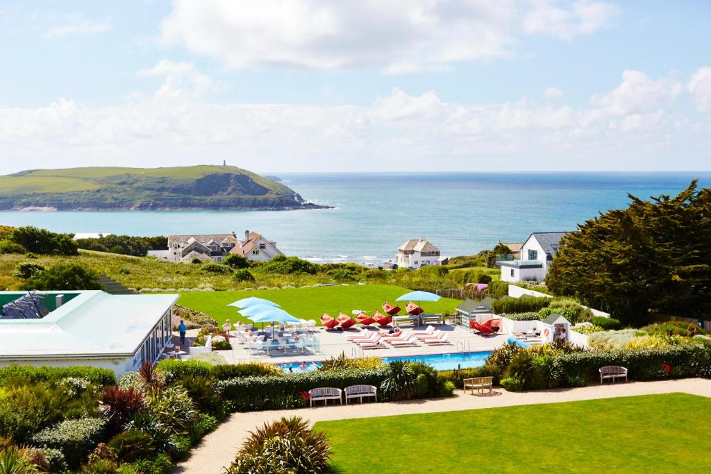 an aerial view of a resort with a pool and the ocean at St Moritz Hotel and Cowshed Spa in Polzeath