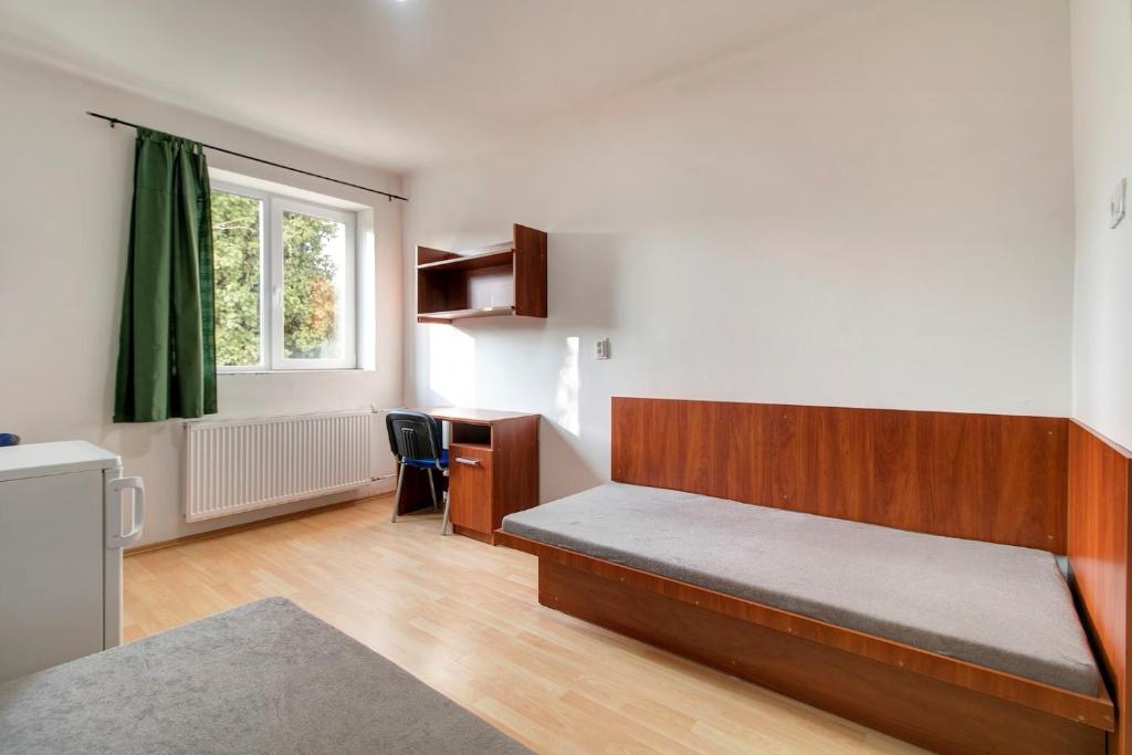 um quarto com uma cama, uma secretária e uma janela em Óbudai Diákszálló em Budapeste