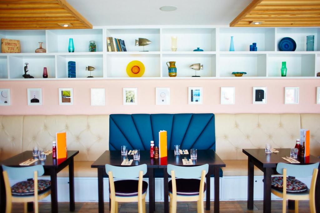 a dining room with two tables and chairs at St Moritz Hotel and Cowshed Spa in Polzeath
