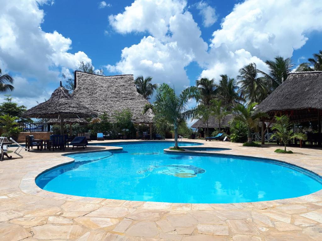 a swimming pool at a resort with palm trees at Kijiji Beach Resort in Dar es Salaam