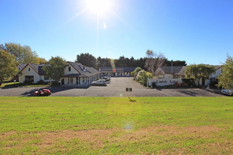 a yard with a lot of houses and a field of grass at Kapiti Lindale Motel and Conference Centre in Paraparaumu