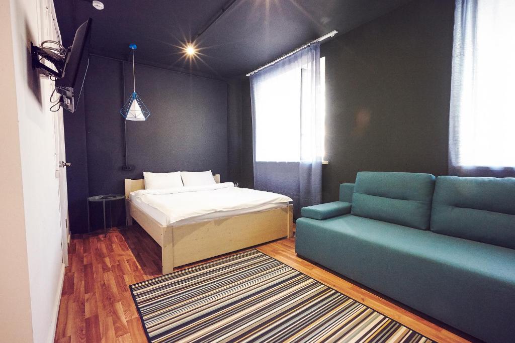 ニジニ・ノヴゴロドにあるPiligrim NN-HOTELSのベッドルーム1室(ベッド1台、ソファ、窓付)