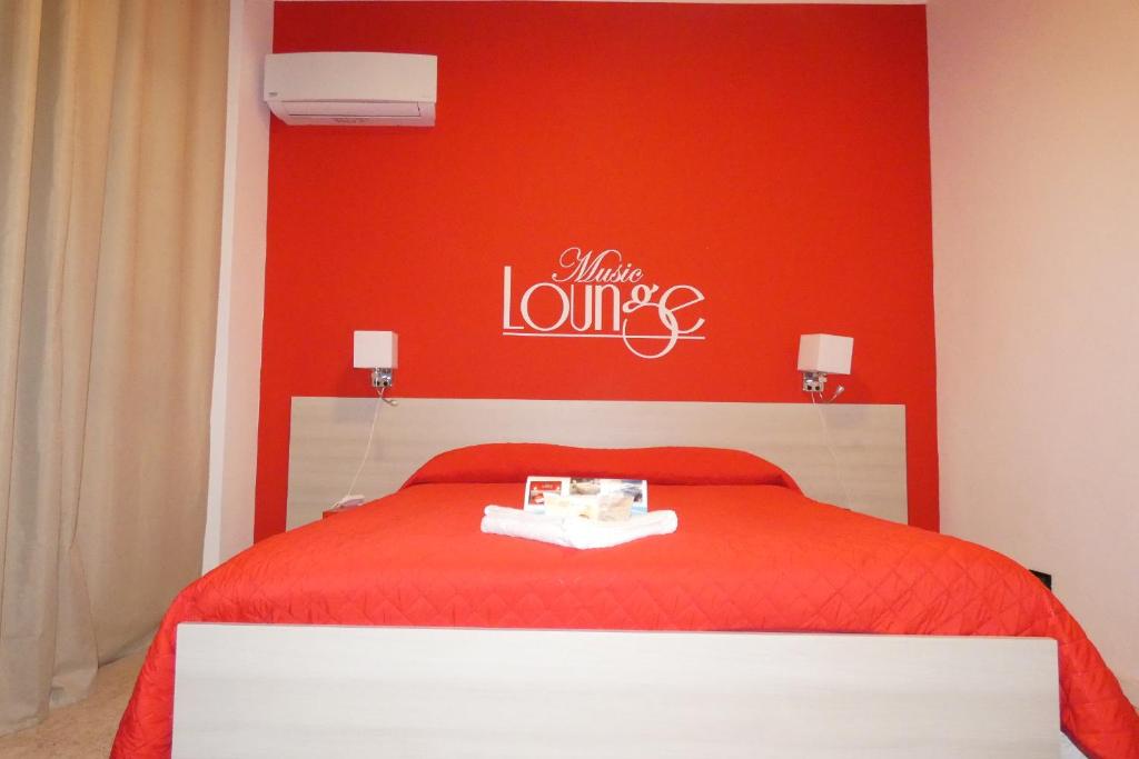 a red bedroom with a bed with a red wall at B&B enjoy music in Villa San Giovanni