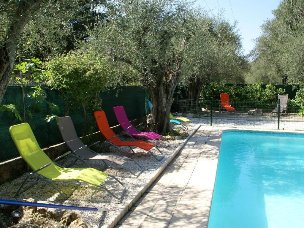 a group of chairs sitting next to a swimming pool at Spacious villa with garden near Grasse in Mouans-Sartoux